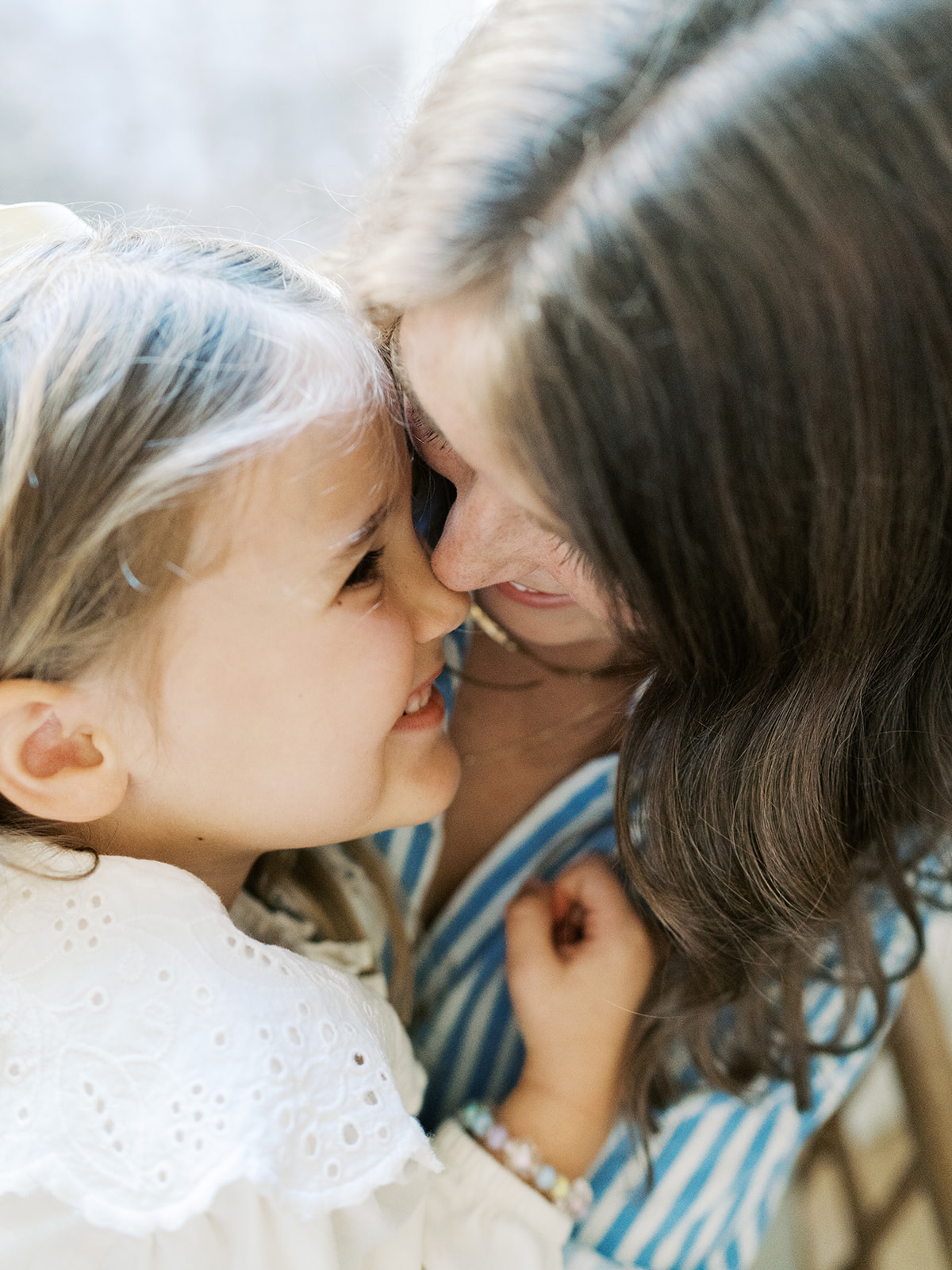 mom cuddles toddler girl