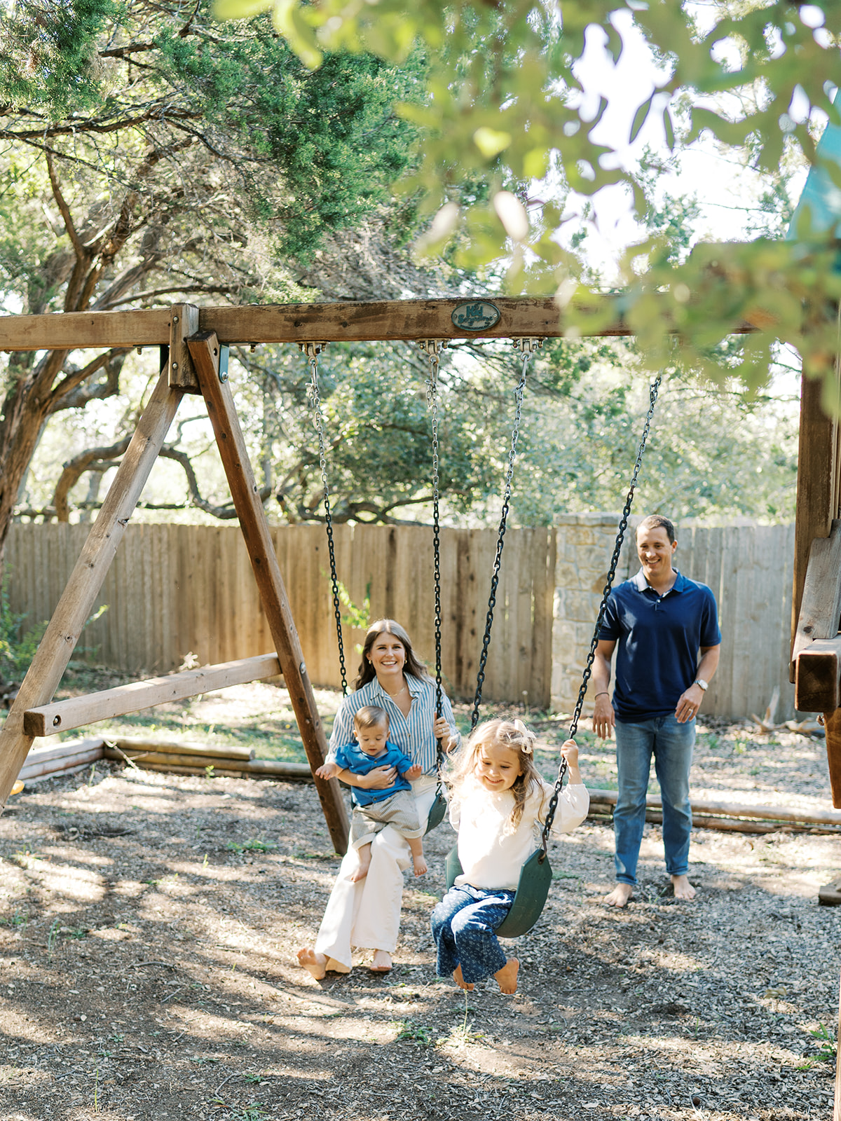 family swings in backyard during at-home family session