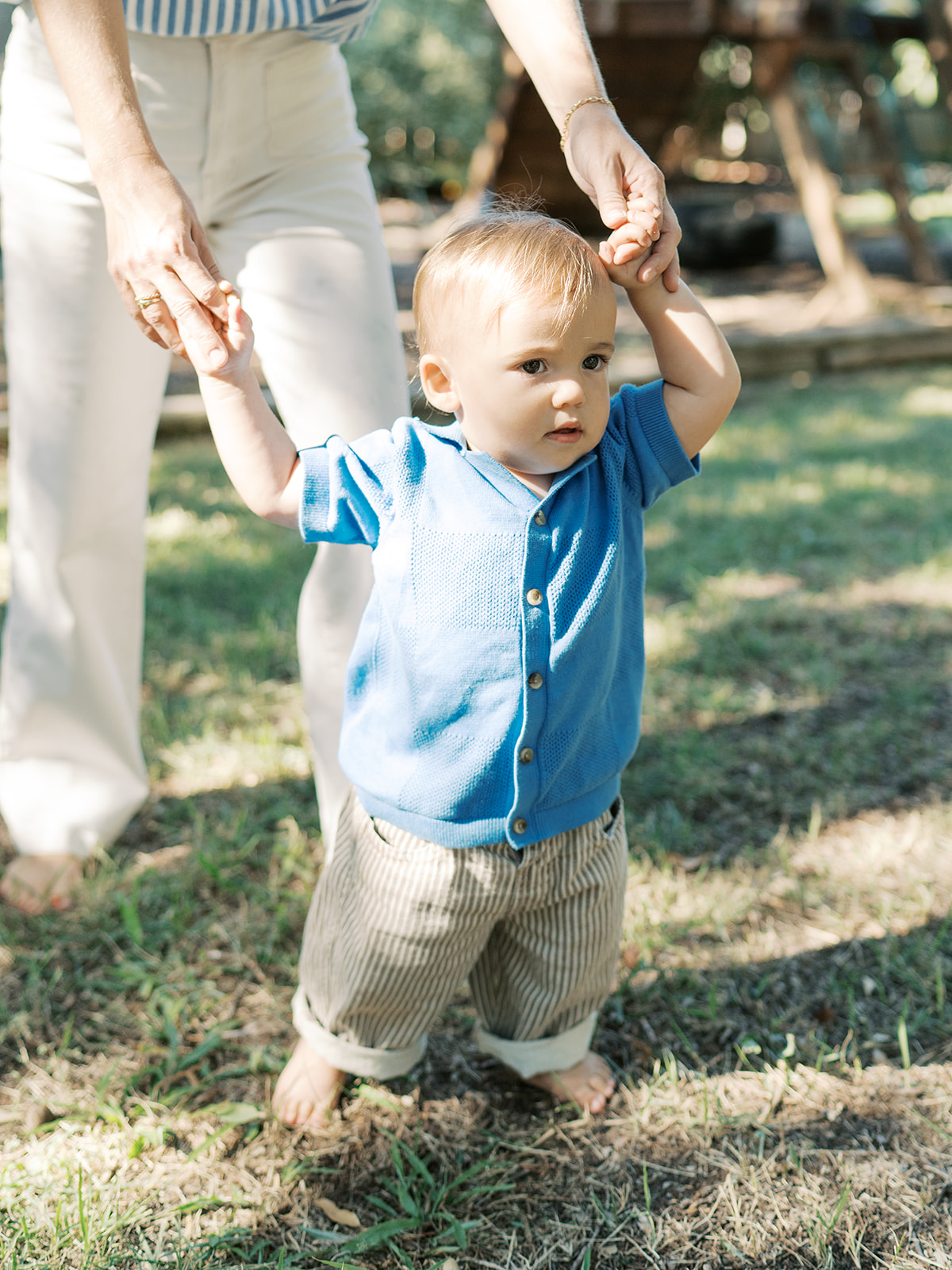 little boy walks with the help of mom