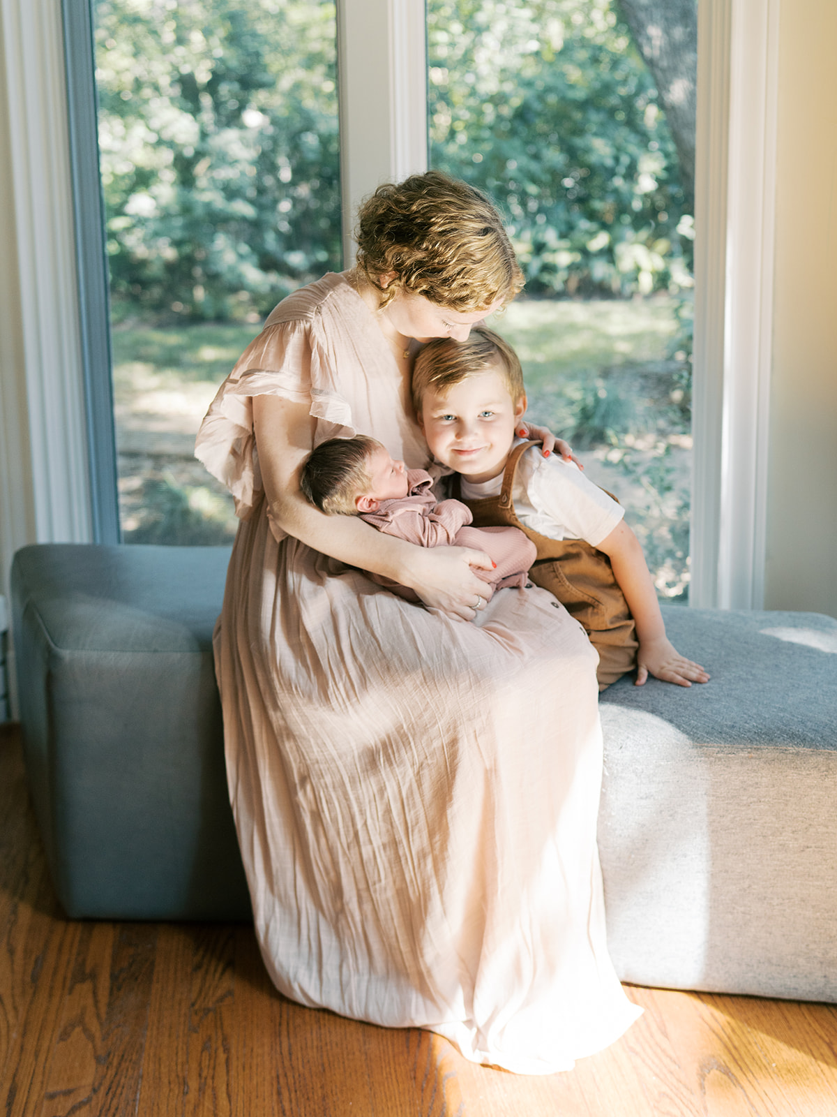 mom holds newborn and son