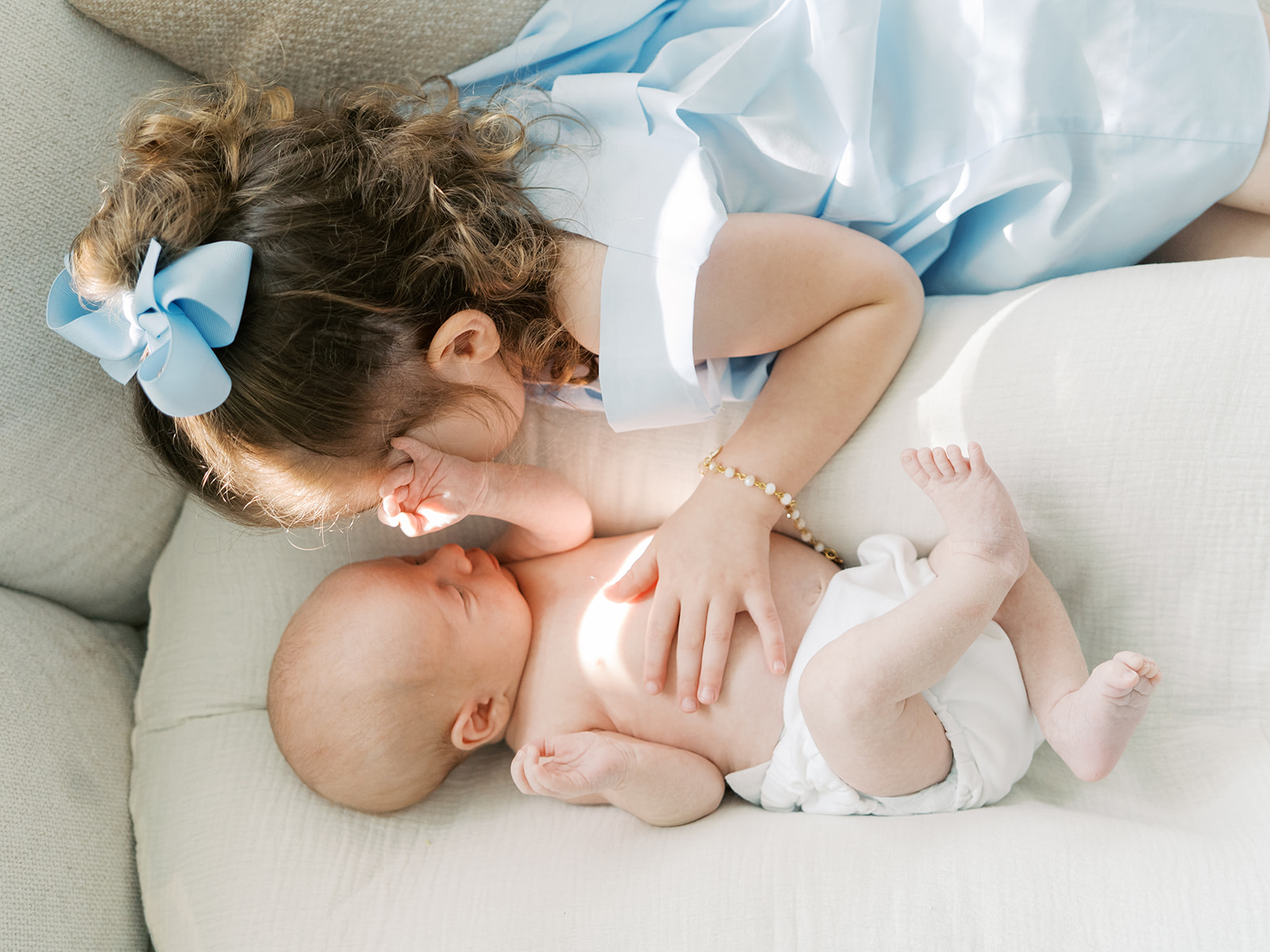 big sister snuggles newborn