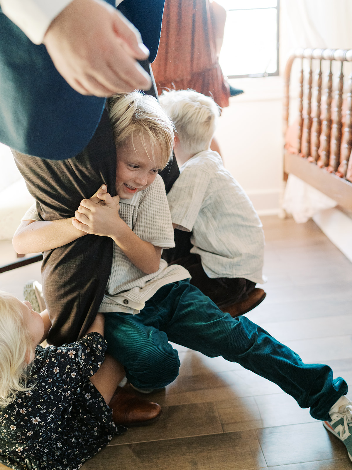children hold on to parent's legs 