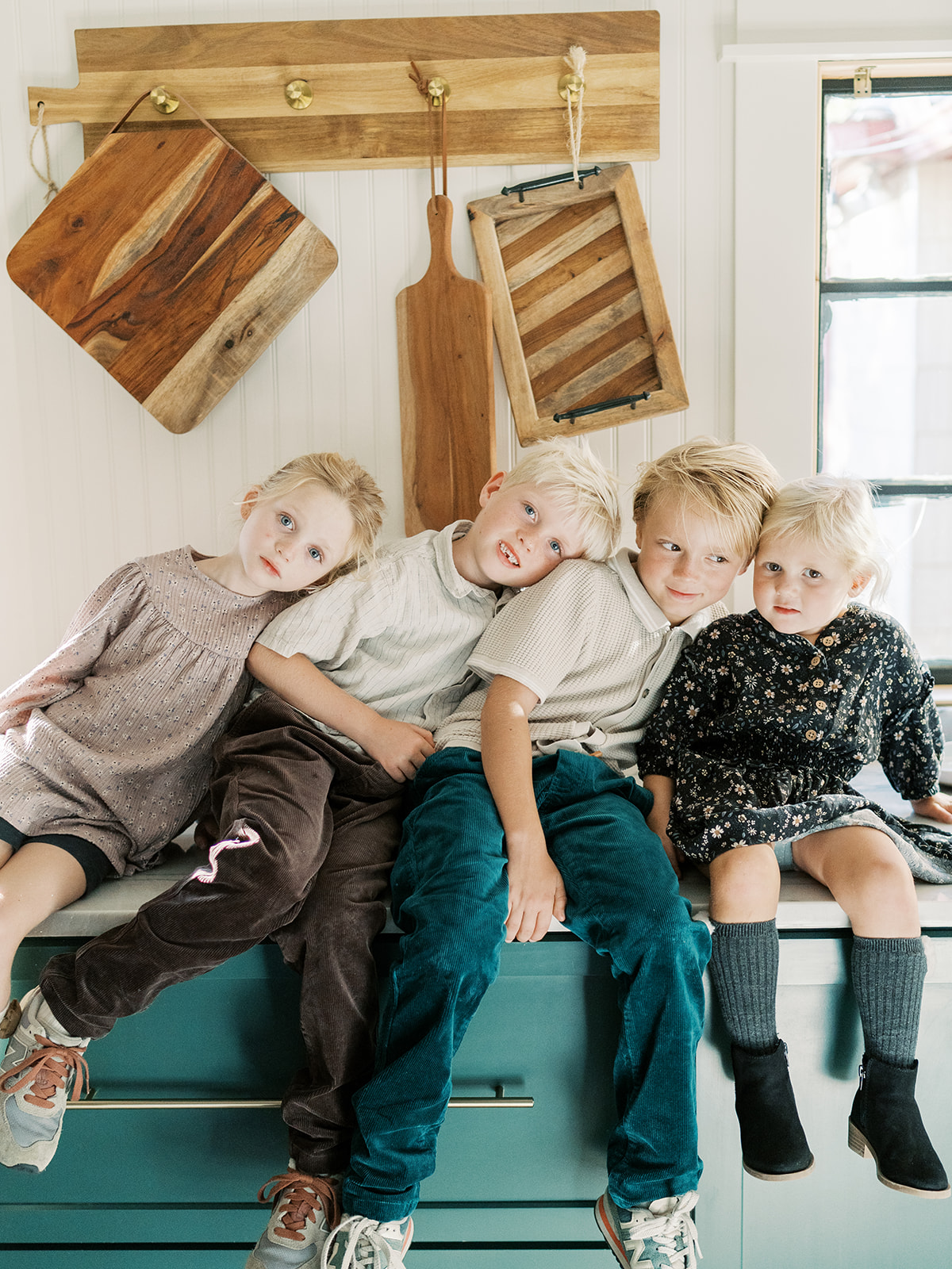 four children sit on counter of family home during session 