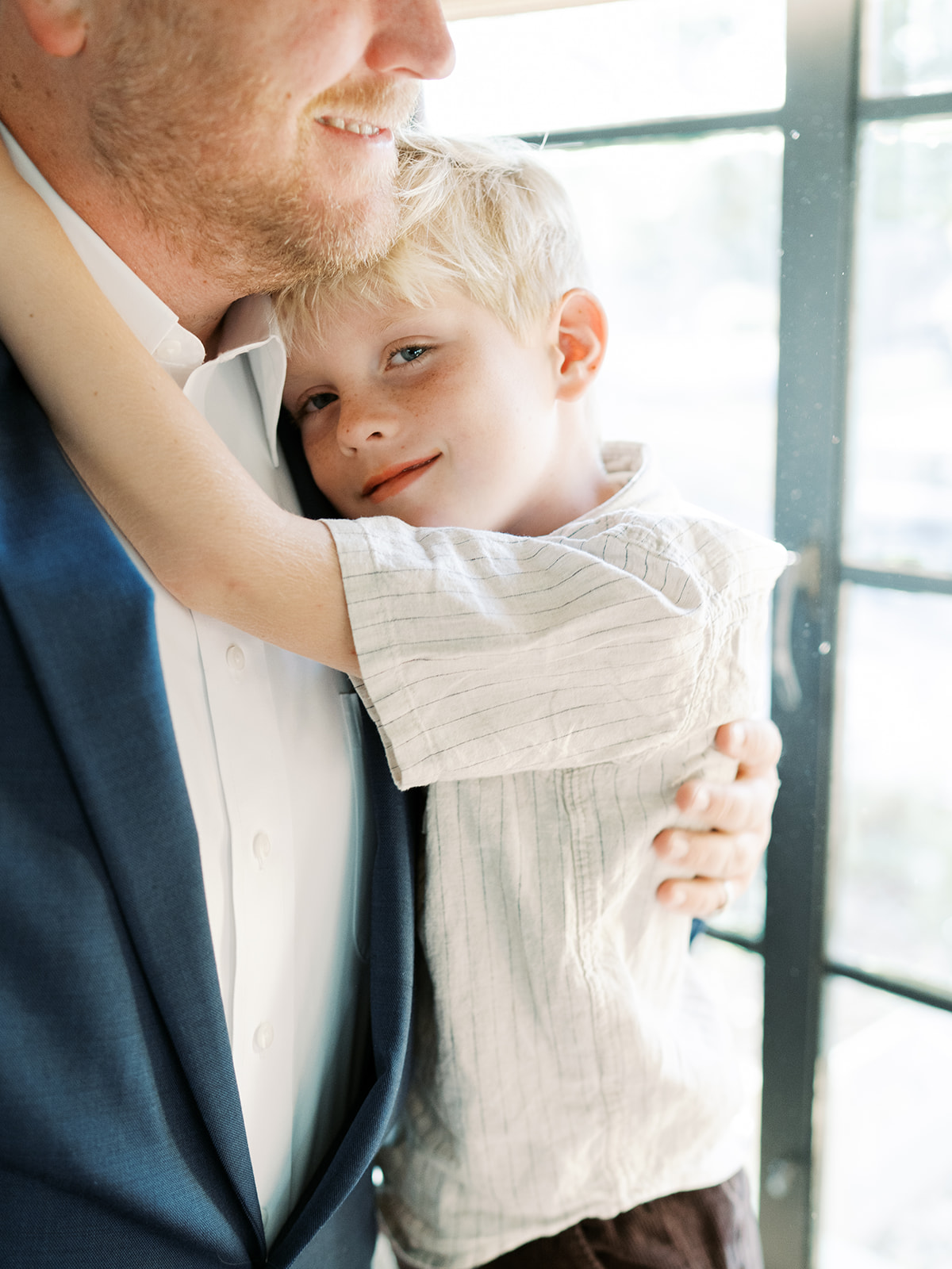 son hugs his dad during in-home full family session 